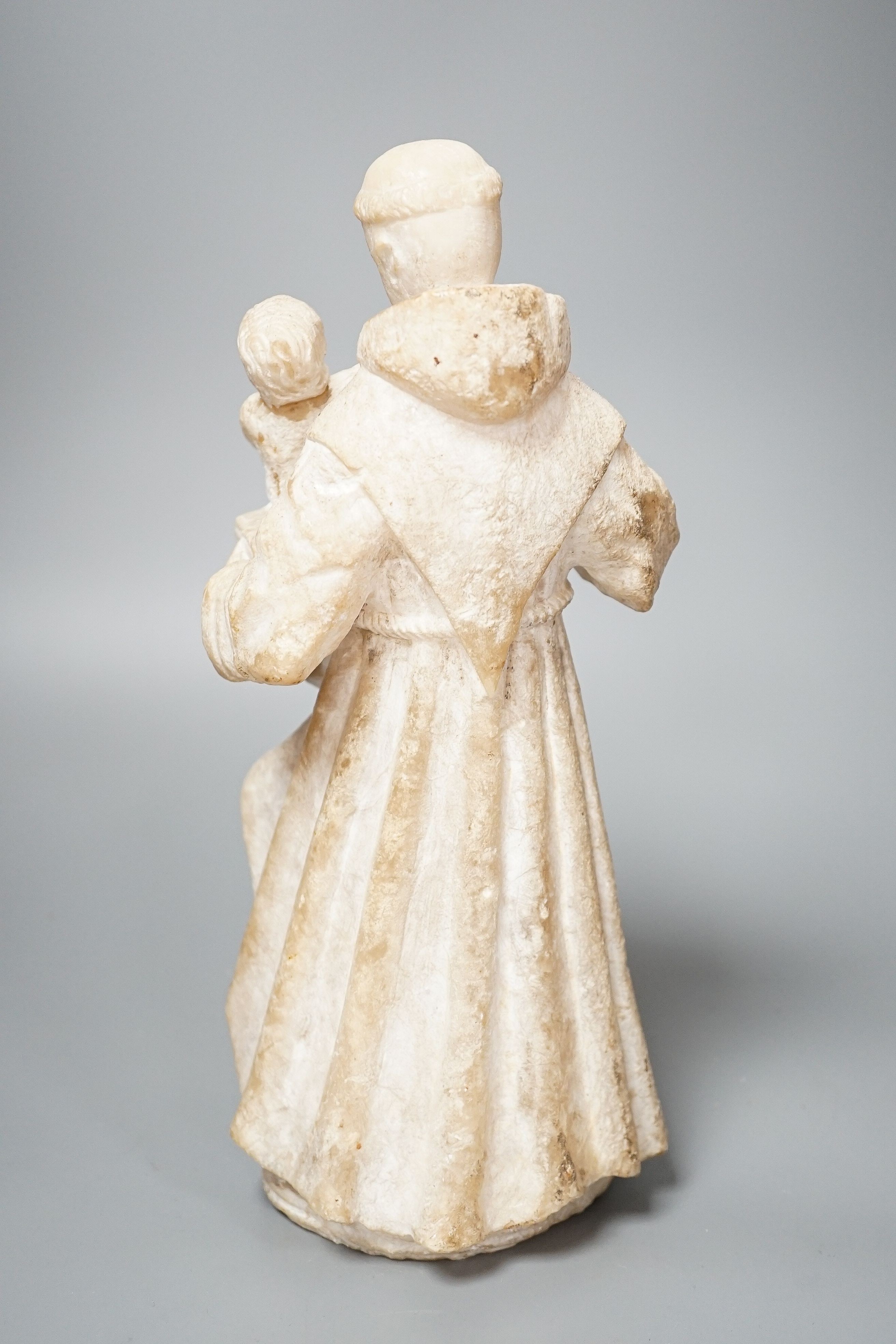 A 19th century carved alabaster group, friar with child 28cm